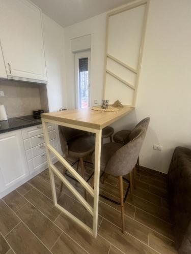 a kitchen with a wooden table and some chairs at Marshall Apartments - Zlatibor in Zlatibor