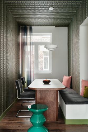 une salle à manger avec une table et un canapé dans l'établissement Edgar Suites Lille - Faidherbe, à Lille