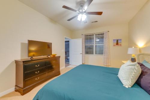 - une chambre avec un lit, un ventilateur de plafond et une télévision dans l'établissement Crow Creek Golf Club Condo with Community Perks!, à Calabash