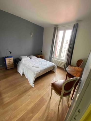 une chambre avec un lit, une chaise et une fenêtre dans l'établissement PARIS- Défense/Puteaux Appartement Cartault, à Puteaux