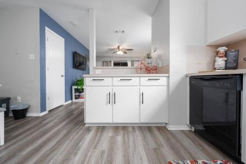 a kitchen with white cabinets and a black fireplace at A Cozy and Peaceful Stay with King Bed in Killeen