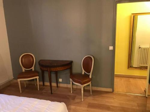 um quarto com uma mesa, 2 cadeiras e um espelho em PARIS- Défense/Puteaux Appartement Cartault em Puteaux