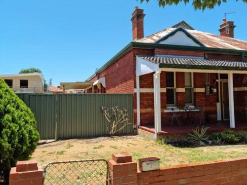 a brick house with a fence in front of it at North Perth Stylish Abode CBD in Perth