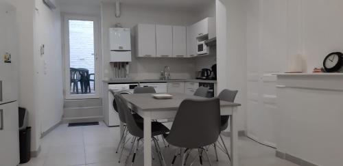 une cuisine blanche avec une table et des chaises dans l'établissement Bol d'air, à Gravelines