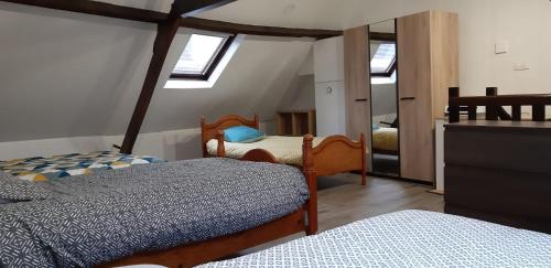 - une chambre mansardée avec 2 lits et un miroir dans l'établissement Bol d'air, à Gravelines