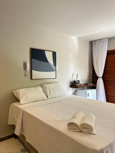 1 dormitorio con 1 cama con 2 toallas en Pousada Minha Praia, en João Pessoa