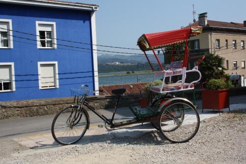 a bike with a chair attached to a rickshaw at Hotel Kerala in San Esteban de Pravia