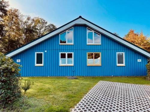 Casa azul con ventanas blancas en Extertal-Ferienpark - Premium Ferienhaus Sauna Wandern #56a en Extertal