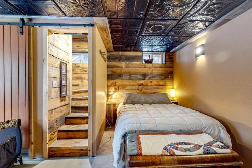 a bedroom with a bed and a wooden wall at Sugarloaf Valley Escape in Carrabassett