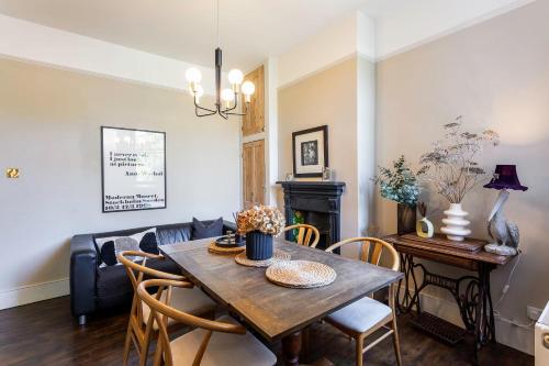 uma sala de estar com uma mesa e um sofá em Tooting's Charming Victorian Garden Hideaway em Londres