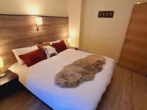 a bedroom with a large white bed with a furry blanket at Alpine Vibes in Sankt Anton am Arlberg