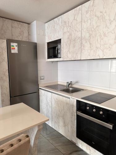 uma cozinha com um frigorífico preto e um lavatório em Boulevard frente a la playa, Central y moderno em Iquique