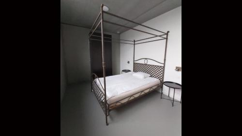 a bedroom with an iron canopy bed with white sheets at Ludovic - 3 bedroom apartment in Essen