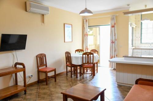 een woonkamer met een eettafel en stoelen bij Vau Costa Apartment in Portimão