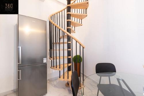 a staircase in a room with a chair and a refrigerator at A lovely duplex maisonette just of Spinola w/WIFI by 360 Estates in St. Julianʼs