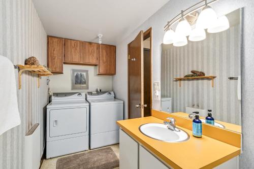 a bathroom with a washer and dryer and a sink at Sunny, Spacious & Pet Friendly - Creekside #39 in Bear Valley