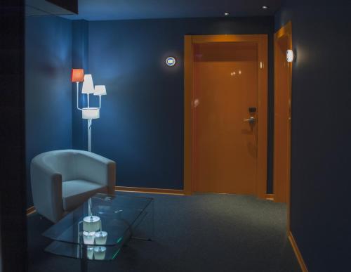a blue room with a chair and a glass table at Resotel in Villares de la Reina