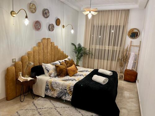 Schlafzimmer mit einem Bett mit einem großen Kopfteil aus Holz in der Unterkunft Maarif Cosy 4 lits Parking wifi Netflix Gratuit in Casablanca