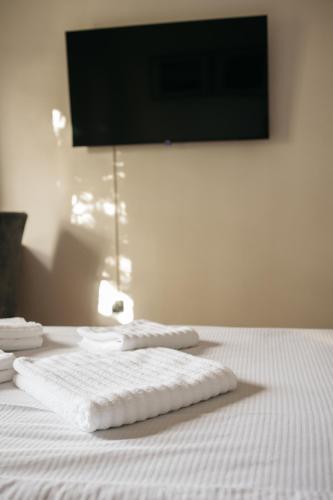 a white bed with two towels on top of it at Macao Apartmani in Vinkovci
