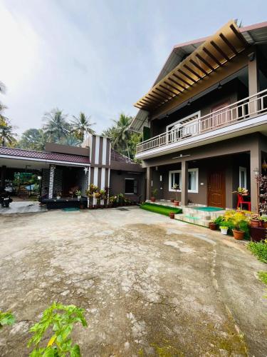a large house with a driveway in front of it at Linn View Home Stay Munnar in Munnar
