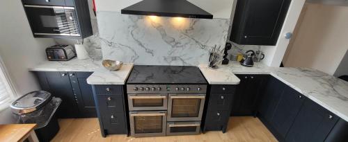 a kitchen with a stove and a marble counter top at Purbeck Lodge in Swanage