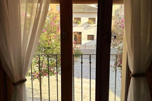 a view of a balcony from a window with curtains at Castle House Xativa in Xàtiva