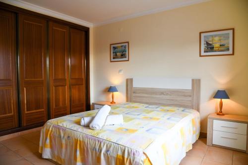 a bedroom with a bed with two tables and two lamps at Apartment Mar à Vista in Portimão