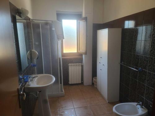 La salle de bains est pourvue de 2 lavabos, d'une douche et d'un miroir. dans l'établissement Riccio - La Cantina del contadino, à Rende