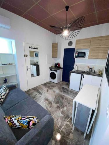 un salon avec un canapé et une cuisine dans l'établissement Apt Charmant, Proche Gare et Centre Historique - Climatisation et WIFI, à Montpellier