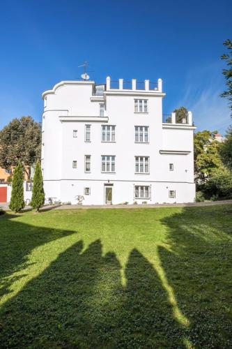 a large white building on a grassy field at Apartments Villa Whitehouse in Ostrava