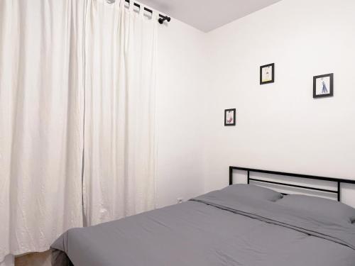 - une chambre avec un lit et un rideau blanc dans l'établissement Charmant appartement proche de la Tour Eiffel, à Paris