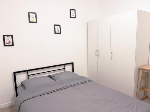 - une chambre avec un lit et une armoire blanche dans l'établissement Charmant appartement proche de la Tour Eiffel, à Paris