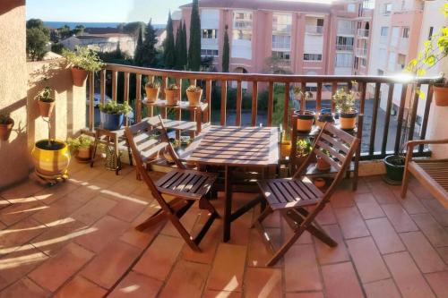- un balcon avec une table et deux chaises dans l'établissement Le Ciel Bleu - vue mer, toute à pied plage et commerce, à Fréjus