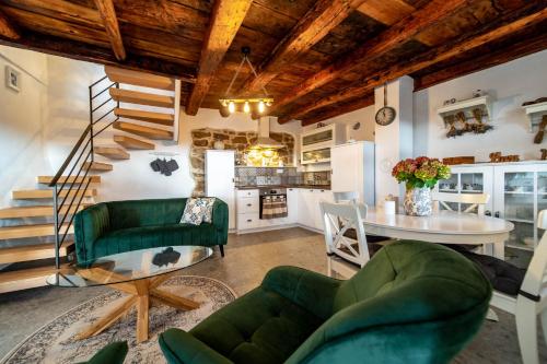 House Filumena في لوبار: غرفة معيشة مع أريكة خضراء وطاولة