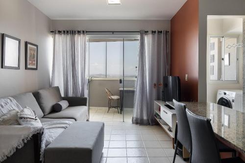 un soggiorno con divano e tavolo di Unique Residence, próximo ao Parque e Shopping Flamboyant a Goiânia
