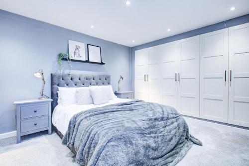 sypialnia z dużym łóżkiem i białymi szafkami w obiekcie Modern 3 Bedroom House Dog Friendly w mieście Broomfield