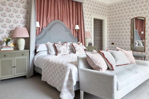 a bedroom with a bed and a chair at Leonardslee House at Leonardslee Lakes & Gardens in Horsham