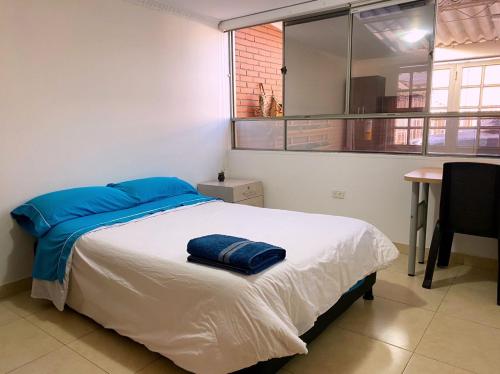 a bedroom with a bed and a table and a window at Casa 30 in Bogotá