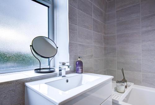 a bathroom with a white sink and a mirror at Modern 3 Bedroom House Dog Friendly in Broomfield