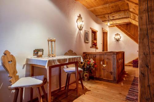 a room with a table and two stools in a room at Ferienwohnung Manuelas Hofschank in Auna di Sopra