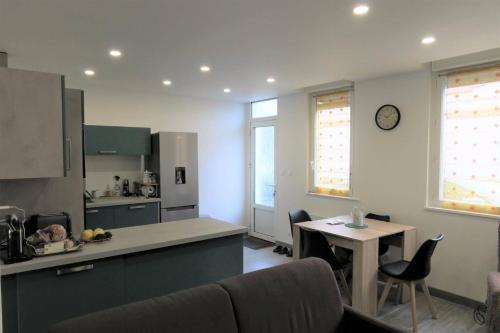 une cuisine avec un comptoir et une table avec des chaises dans l'établissement Appartement rénové avec WIFI bien équipé au centre ville de PERROS-GUIREC - Ref 940, à Perros-Guirec