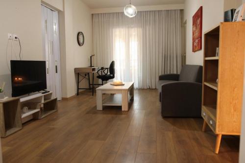 salon z kanapą i telewizorem w obiekcie Nikis apartment w mieście Larisa