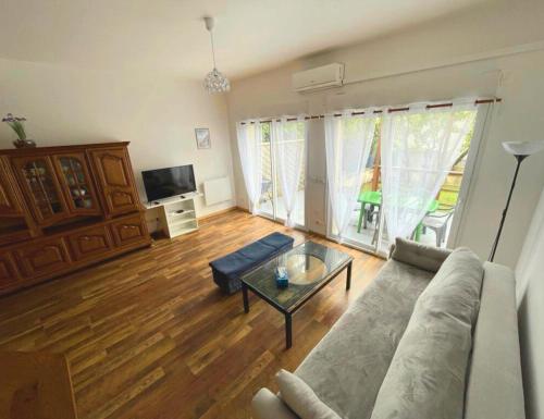 uma sala de estar com um sofá e uma mesa em 9 min from Paris&Orly - House with terrace/garden em Arcueil