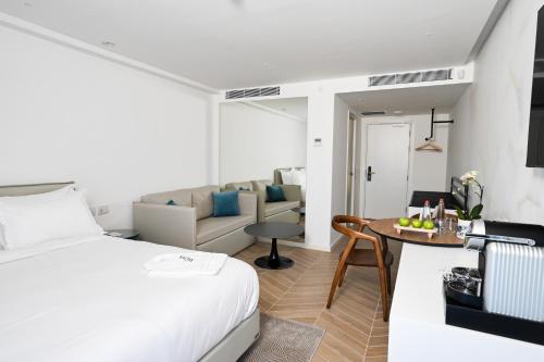 a bedroom with a bed and a living room at AKOYA HOTEL in Eilat