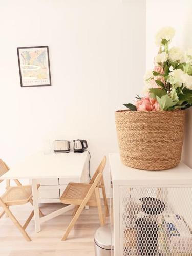 une chambre avec une table et une plante dans un panier dans l'établissement Très Joli Studio à 150 m de la mer, à Nice