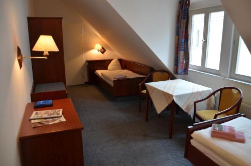 ein Hotelzimmer mit zwei Betten und einem Tisch in der Unterkunft Komenský Gäste- und Tagungshaus in Herrnhut