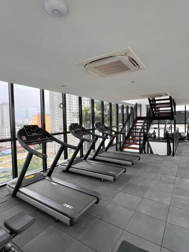 a row of treadmills in a gym with windows at Georgetown Skypool Urban 3BR Family & Baby-Friendly 9pax Seaview Penang in Jelutong