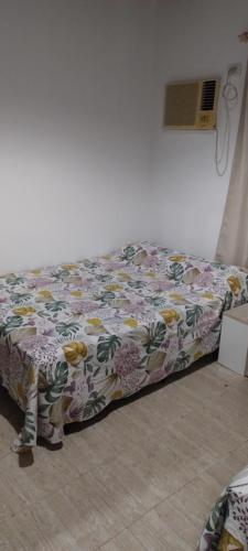 a bed in a room with a flowered blanket at Departamento alquiler diario Resistencia in Resistencia