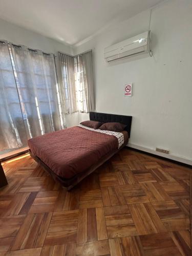 ein Schlafzimmer mit einem Bett in einem Zimmer mit Holzböden in der Unterkunft Viva Chile Providencia - Bustamante in Santiago