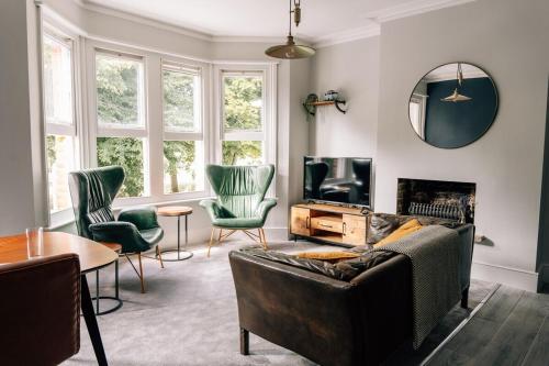 a living room with a couch and chairs and a mirror at Tranquility in Worthing